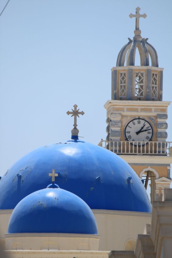 Picture of the  Blue Church Domes And Clock Tower Side Aligned Against Blue Sky  - Fira, Santorini, Greece