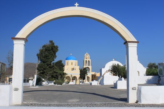 Picture of the  Large Yellow Church With Blue Dome Through Archway - Oia, Santorini, Greece