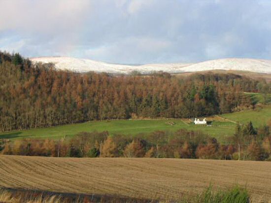 A Farmhouse  in Creiff  with snow on the hills in the background